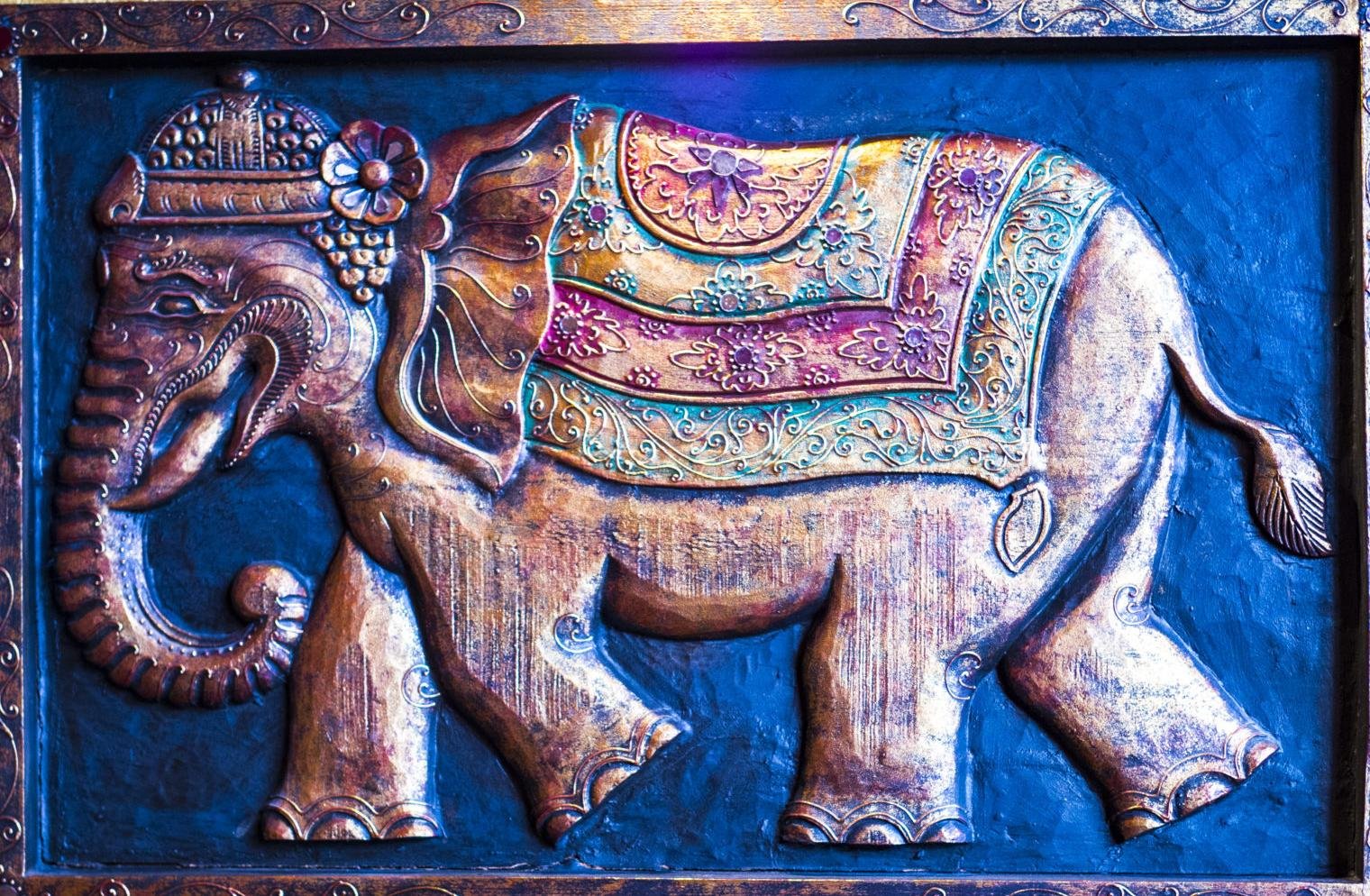 Elefanten-Relief auf goldener Ziegelwand