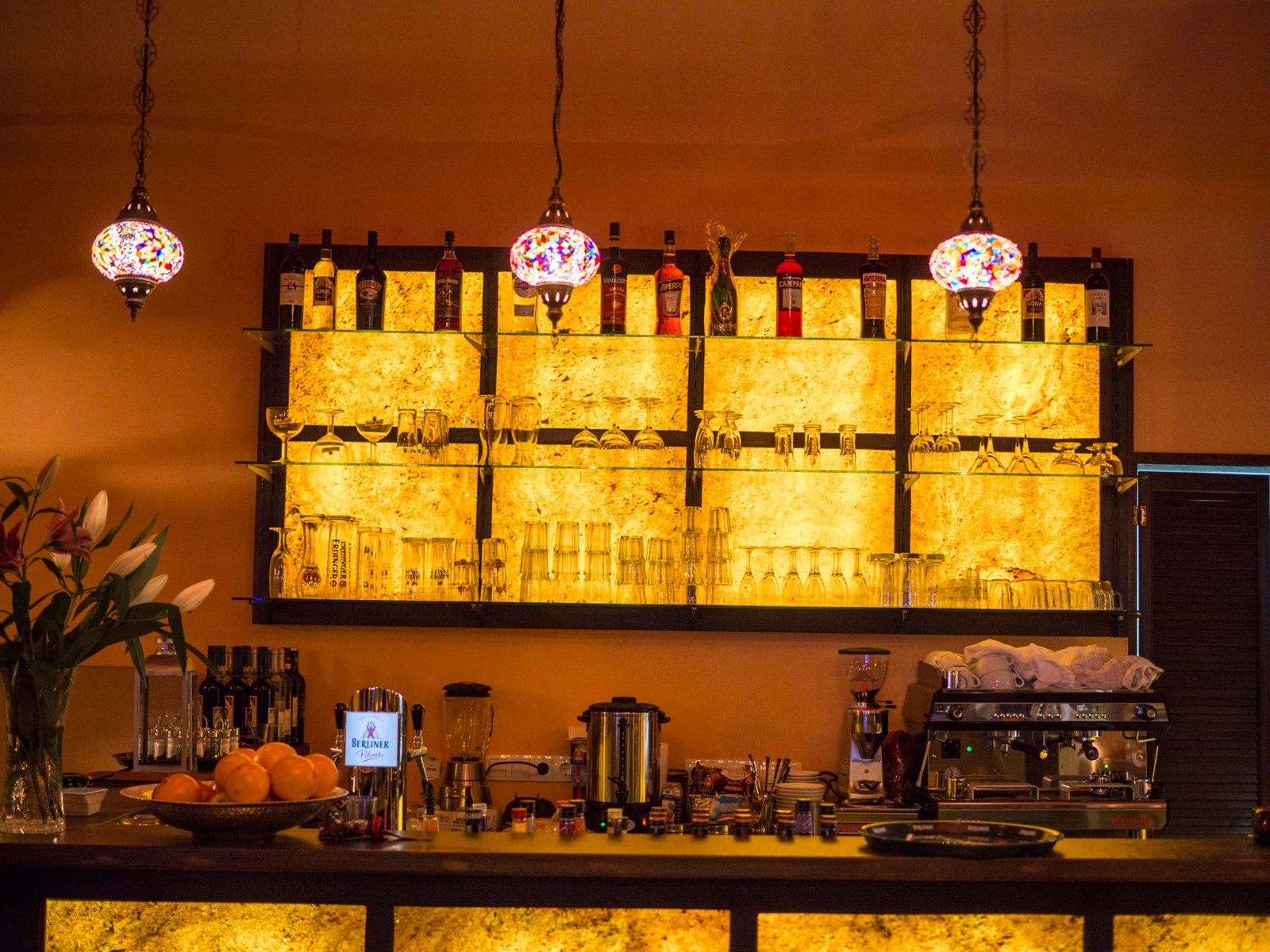 Bar mit orientalischen Mosaiklampen und beleuchteten Onyx-Regalen